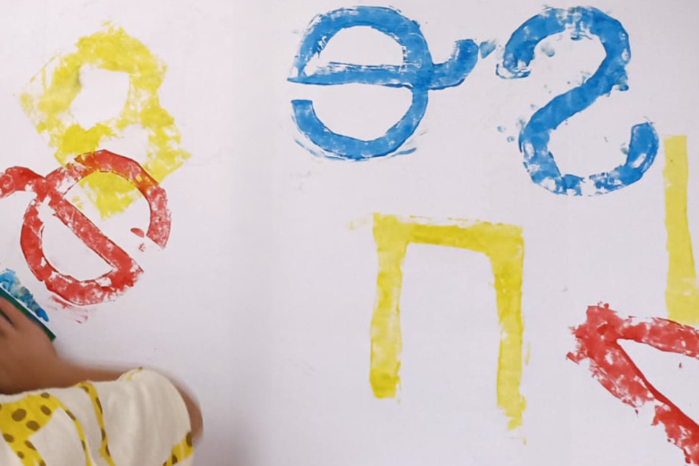 Bambino che colora alcune lettere durante il workshop di Chiara Spinelli