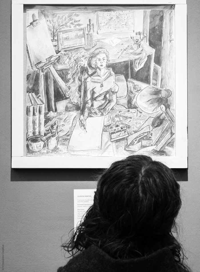 Una persona che osserva un'opera della Mostra collettiva a Cose Belle Festival